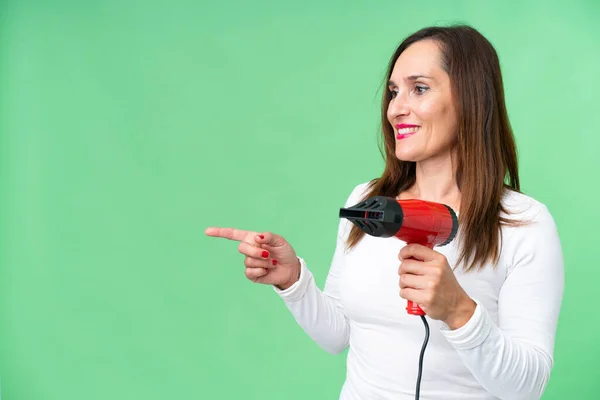Middle Age Woman Holding Hairdryer Isolated Chroma Key Background Pointing — Photo