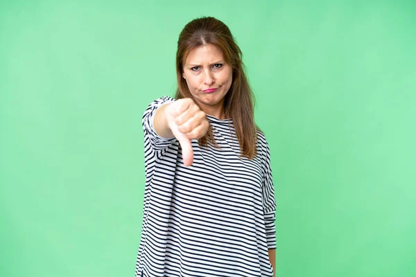 Kobieta Średnim Wieku Odosobnionym Tle Pokazuje Kciuk Dół Negatywnym Wyrazem — Zdjęcie stockowe
