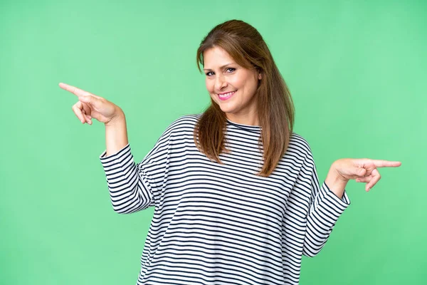 Middle Age Woman Isolated Background Pointing Finger Laterals Happy — Stockfoto