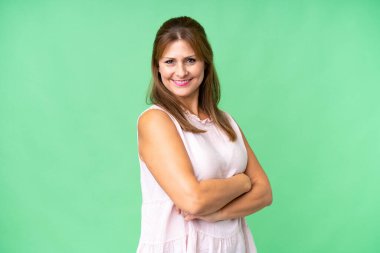 Middle age woman over isolated background with arms crossed and looking forward