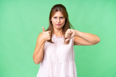 Tecrit edilmiş orta yaşlı bir kadın iyiye-kötüye işaret yapıyor. Evet ya da hayır arasında kararsız