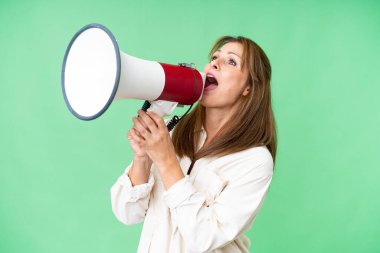 Soyutlanmış arka planda orta yaşlı bir kadın megafondan bağırıyor.