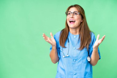 Middle age nurse woman over isolated background with surprise facial expression
