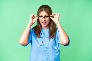 Gözlüklü ve şaşırmış orta yaşlı bir hemşire.