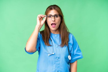 Gözlüklü ve şaşırmış orta yaşlı bir hemşire.