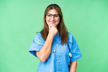 Gözlüklü ve gülümseyen orta yaşlı bir hemşire.