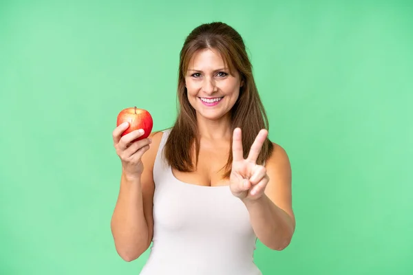 Frau Mittleren Alters Mit Einem Apfel Vor Isoliertem Hintergrund Lächelt — Stockfoto