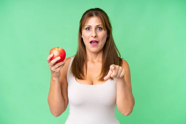 Frau Mittleren Alters Mit Einem Apfel Vor Isoliertem Hintergrund Überrascht — Stockfoto