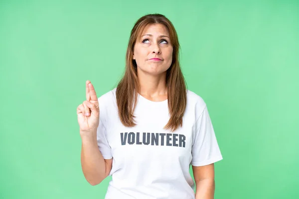 stock image Middle age volunteer woman over isolated background with fingers crossing and wishing the best