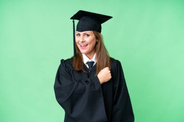 Middle age university graduate woman over isolated background celebrating a victory