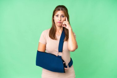 Orta yaşlı, kırık kollu ve soyutlanmış arka planda askı takan biri.