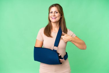 Orta yaşlı, kırık kollu ve izole edilmiş arka planda askılık takan biri.