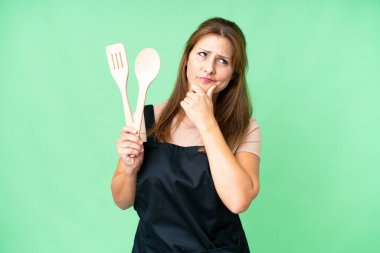 Orta yaşlı, beyaz bir kadın, izole bir arka planda merdane tutuyor. Şüpheleri var.