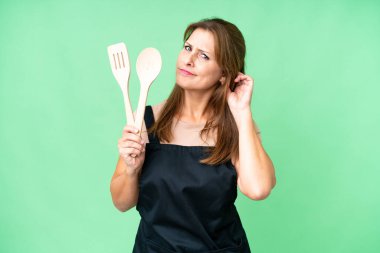 Orta yaşlı, beyaz bir kadın, izole bir arka planda merdane tutuyor. Şüpheleri var.