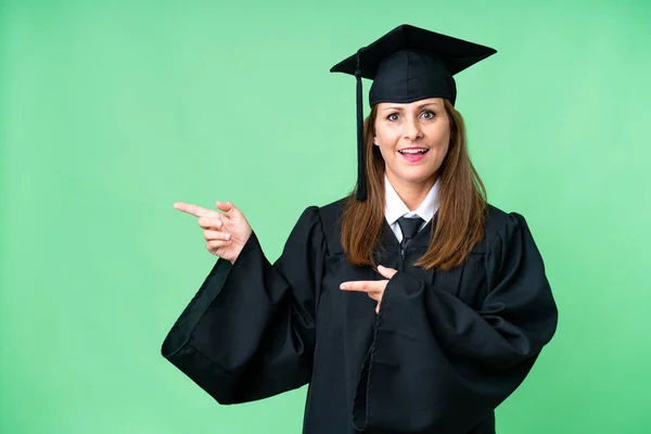 Edad Media Mujer Graduada Universitaria Sobre Fondo Aislado Sorprendido Apuntando — Foto de Stock