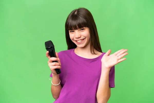 Little Singer Girl Picking Microphone Isolated Background Saluting Hand Happy — Stock Photo, Image