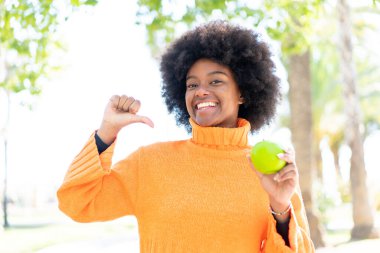 Açık havada elmalı Afro-Amerikalı kız gururlu ve kendini beğenmiş.