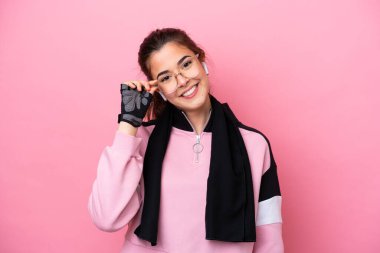 Pembe arka planda gözlüklü ve mutlu bir Brezilyalı genç kadın.