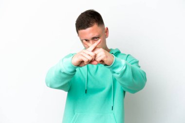 Genç Brezilyalı bir adam beyaz arka planda izole edilmiş bir şekilde bir eylemi durdurmak için el hareketi yapıyor.