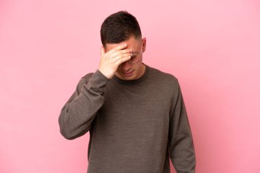 Pembe arka planda başağrısı olan Brezilyalı genç bir adam.