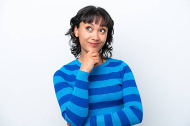 Genç Arjantinli kadın beyaz arka planda izole edilmiş ve yukarı bakıyor.