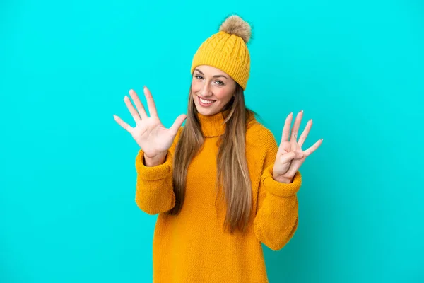 年轻的高加索女人穿着蓝色背景的冬季夹克 手指有9根 — 图库照片