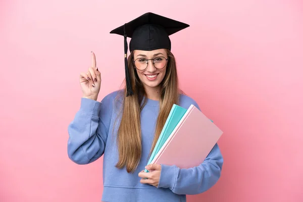 Mladá Studentka Nosí Absolventský Klobouk Izolované Růžovém Pozadí Ukazuje Nahoru — Stock fotografie