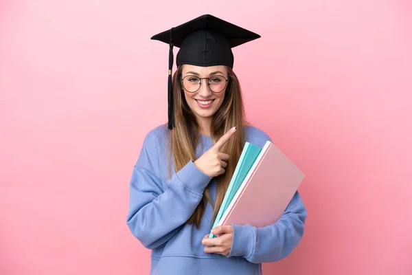 Jovem Estudante Usando Chapéu Pós Graduação Isolado Fundo Rosa Apontando — Fotografia de Stock