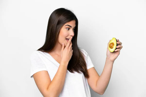 Junge Brasilianerin Mit Einer Avocado Auf Weißem Hintergrund Und Schockiertem — Stockfoto