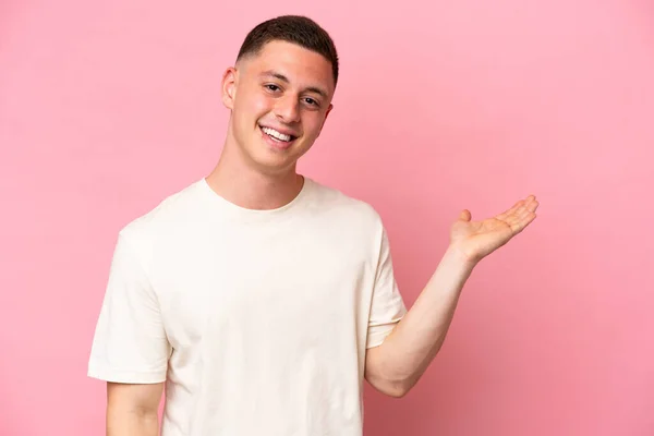 Young Brazilian Man Isolated Pink Background Holding Copyspace Imaginary Palm — Stock Photo, Image