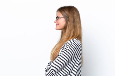 Beyaz arka planda yalıtılmış beyaz tenli genç bir kadın var.