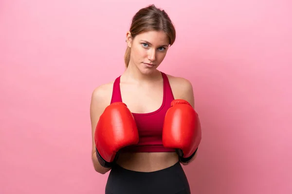 Young caucasian woman isolated on pink background with boxing gloves