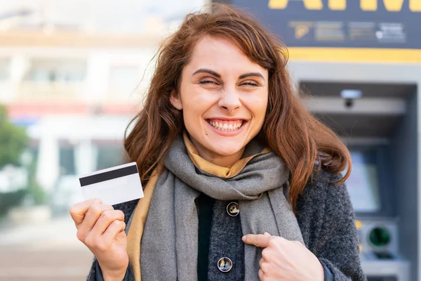 Brunetka Kobieta Trzyma Kartę Kredytową Świeżym Powietrzu Zaskakującym Wyrazem Twarzy — Zdjęcie stockowe