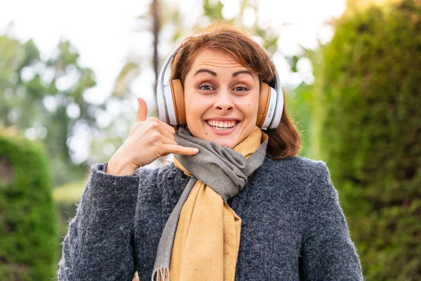 Μπρουνέτ Γυναίκα Ακούγοντας Μουσική Ακουστικά Εξωτερικούς Χώρους Κάνοντας Τηλεφωνική Χειρονομία — Φωτογραφία Αρχείου