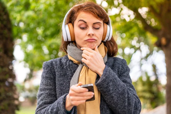 Μελαχρινή Γυναίκα Ακούγοντας Μουσική Ακουστικά Εξωτερικούς Χώρους Σκέψης Και Στέλνοντας — Φωτογραφία Αρχείου