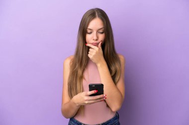 Young Lithuanian woman isolated on purple background thinking and sending a message
