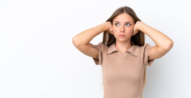 Beyaz arka planda izole edilmiş genç Litvanyalı kadın hayal kırıklığına uğramış ve kulaklarını kapatmış.