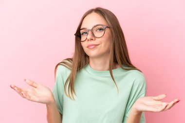 Genç Litvanyalı kadın pembe arka planda gözlüklü ve kuşkuları olan
