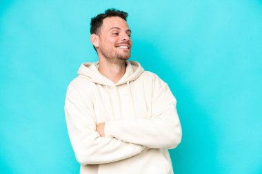 Beyaz tenli yakışıklı adam mavi arka planda izole edilmiş.