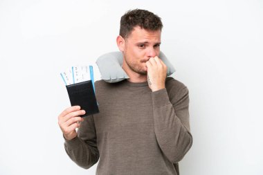 Young caucasian man holding a passport isolated on white background having doubts
