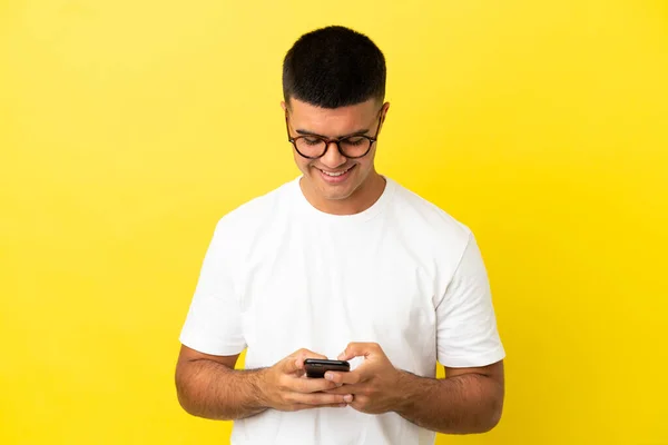 Junger Gutaussehender Mann Über Isoliertem Gelben Hintergrund Sendet Eine Nachricht — Stockfoto