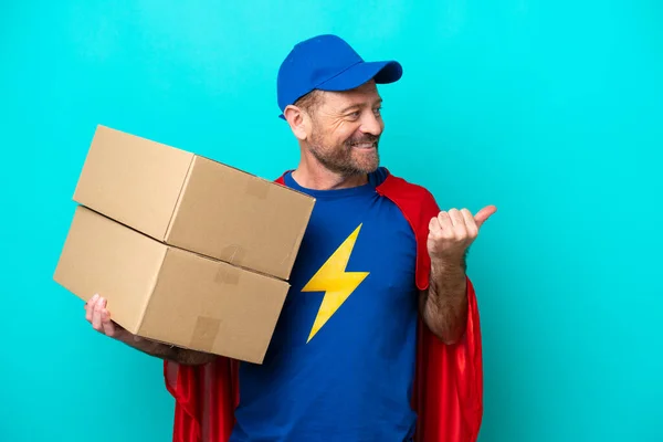 Super Hero Delivery Man Isolated Blue Background Pointing Side Present — Stock Photo, Image