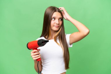 Kafkasyalı genç bir kız saç kurutma makinesini soyutlanmış arka planda tutuyor. Şüpheleri var ve kafası karışık.