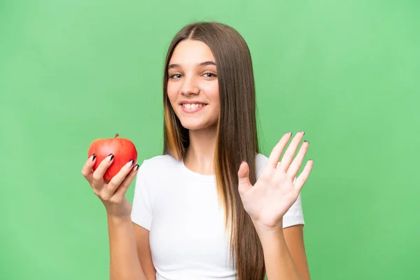 年少无知的高加索女孩 提着一个苹果 抱着一个孤立的背景 手牵着手 带着快乐的表情向她致意 — 图库照片