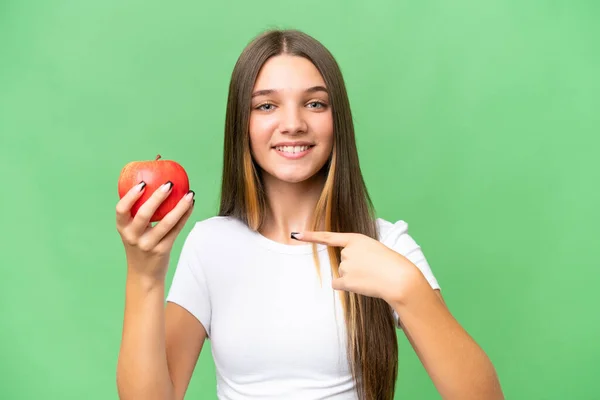 在与世隔绝的背景下抱着一个苹果并指着它的少女 — 图库照片