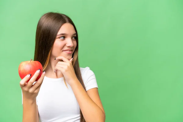 Teenager Kaukasischen Mädchen Mit Einem Apfel Über Isolierten Hintergrund Denken — Stockfoto