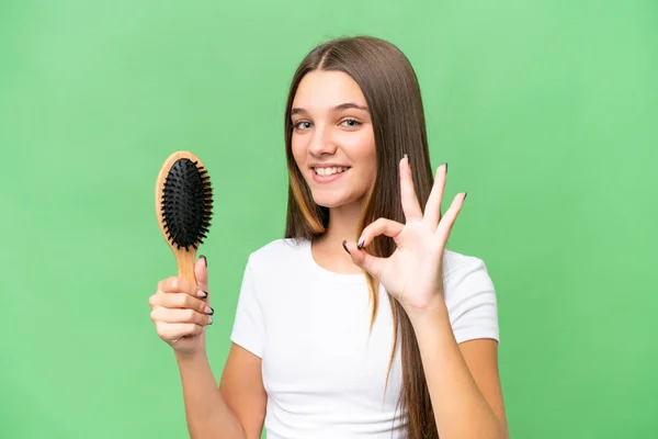 Teenager caucasian girl with hair comb over isolated background showing ok sign with fingers