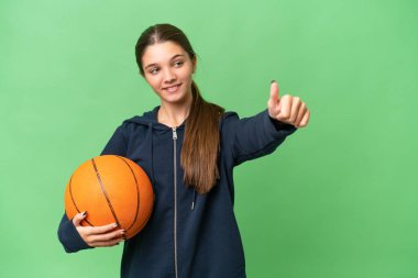 İzole edilmiş arka planda basketbol oynayan beyaz bir kız başparmak işareti yapıyor.