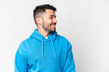 Young handsome caucasian man over isolated white background looking to the side and smiling