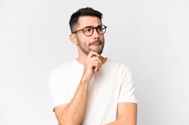 Young handsome caucasian man over isolated white background having doubts and thinking